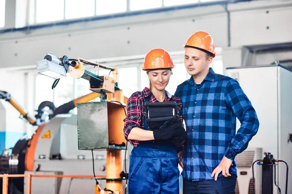 Ingegneri industriali di sesso maschile e femminile hanno discussione e utilizzando controller di settore. Lavorano in una fabbrica industriale . — Foto Stock