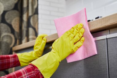 Young woman in gloves doing housework, cleaning the kitchen