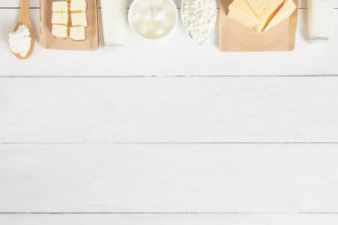 Süt ürünlerinin ve süt ürünlerinin en üst görüntüsü. Süt, ekşi krema, mozarella, tereyağı, peynir çeşitleri. Düz plan. Metin uzayı.