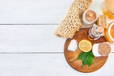 Çevre dostu doğal temizleyiciler: Soda, sabun, sirke, tuz, limon ve ahşap masadaki fırça. Sıfır atık. Üst görünüm.