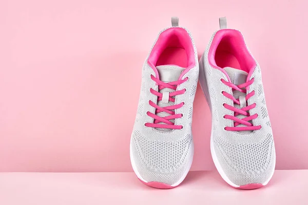 Running sports shoes on pink background, Pair of fashion stylish sneakers