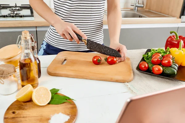 Κοντινό πλάνο χέρια κοπής τομάτες, προετοιμασία για βιολογικά χορτοφαγικό γεύμα με πιπεριές και αγγούρι, κουζίνα φόντο — Φωτογραφία Αρχείου