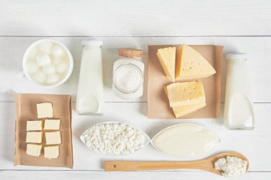 Süt ürünleri ve süt ürünlerinin beyaz arkaplandaki üst görüntüsü. Süt, ekşi krema, mozzarella, kefir, yoğurt, tereyağı, peynir çeşitleri. Düz Düzen
