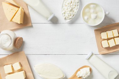 Süt ürünleri ve süt ürünlerinin beyaz arkaplandaki üst görüntüsü. Süt, ekşi krema, mozzarella, kefir, yoğurt, tereyağı, peynir çeşitleri. Düz Düzen