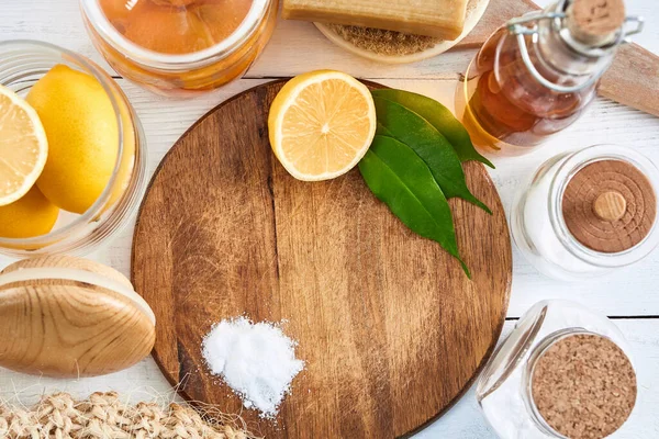 Eco-friendly natural cleaners: baking soda, soap, vinegar, salt, coffee, lemon and brush on wooden table. Zero waste concept. Top view.