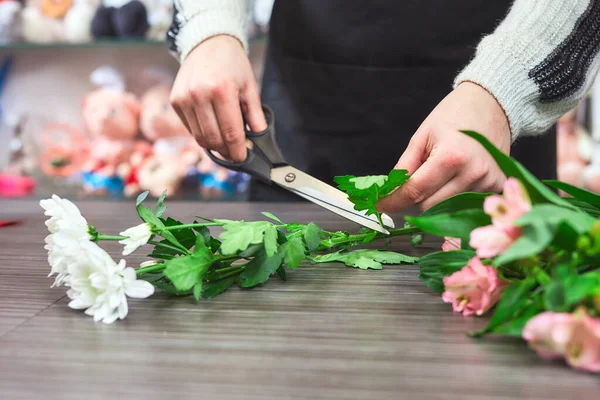 Cropped view of female florist making flower bouquet composition in flower shop. Valentines day concept.