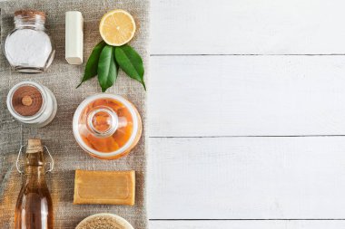 Eco-friendly natural cleaners: baking soda, soap, vinegar, salt, coffee, lemon and brush on a wooden table. Zero waste concept.