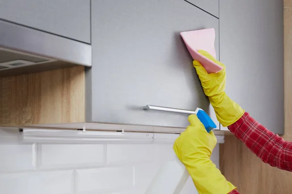 Woman doing Cleaning Kitchen. Washing a kitchen in yellow gloves with pink rag and Detergent. House cleaning