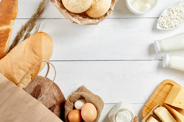 Whole grain bread in ecology paper bag on white wooden background. Top view flat lay. Healthy food. Save ecology concept. Zero waste recycling