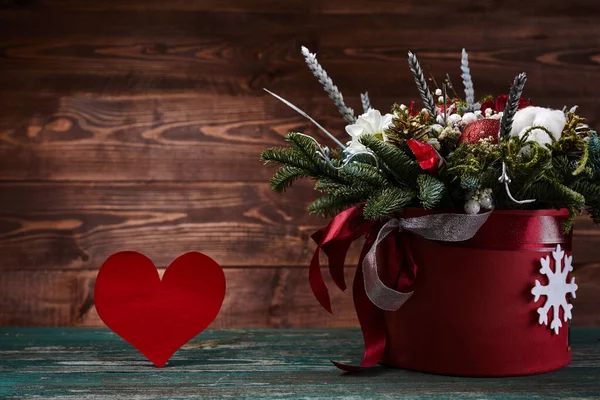 木の背景に赤い紙のハートの箱の中の花 モミの枝を持つ冬の花束 バレンタインデーのコンセプト — ストック写真