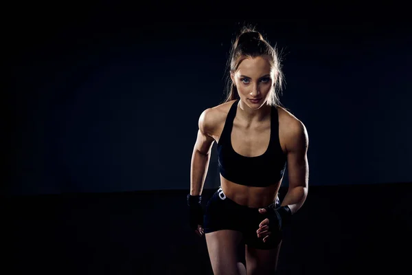 Athlète forte, la femme sprinteuse court sur un fond sombre. Concept sportif. Motivation du coureur avec espace de copie . — Photo