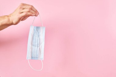 Pembe arka planda tıbbi koruyucu maske.