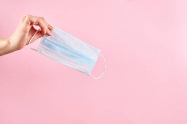 Pembe arka planda tıbbi koruyucu maske.