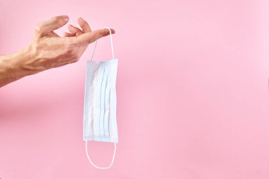 Pembe arka planda tıbbi koruyucu maske.