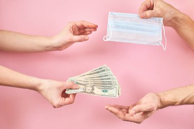 Bir elde tıbbi maske ve dolar, virüslerden korunmak için fiyatların artması kavramı..