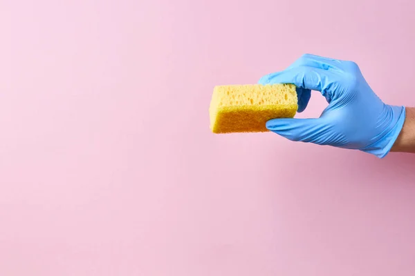 Hand Blue Rubber Protective Glove Holding Yellow Sponge Pink Background — Stock Photo, Image