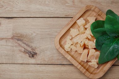 Ahşap arka planda sert peynir ve yeşiller. Üst Manzara. Boşluğu kopyala