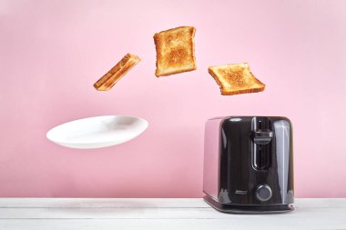 Tostlar modern tost makinesinden fırladı. Bir bardak sütün yanında. Havalandırma yiyeceği ve yemek. Pembe arka planda nefis bir sabah kahvaltısı konsepti.