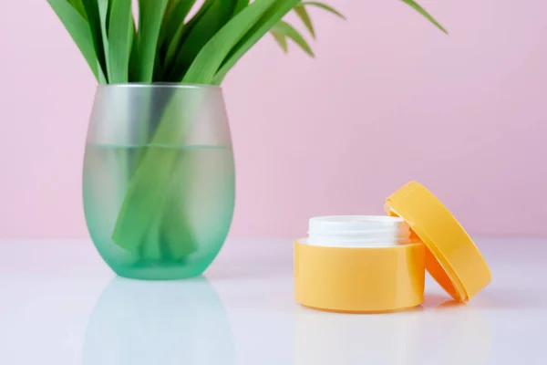 Gele Plastic Container Met Crème Roze Achtergrond Potje Hydraterende Gezichtscrème — Stockfoto