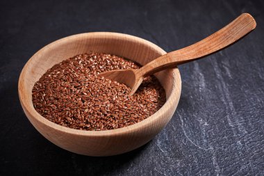 Keten tohumu ve üzerinde kase olan tahta bir kaşık. Sağlıklı yiyecek ve içecek konsepti. Üst Manzara. Kapat.