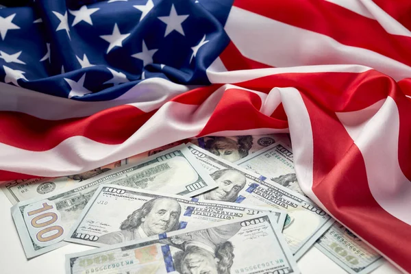 Close up of american flag and dollar cash money. Dollar banknote and United States flag on a background. Economy of USA
