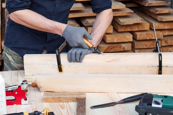 卡彭特的手与刀具一起工作 在木制背景下与飞机一起工作的人 加入木匠的工作 — 图库照片