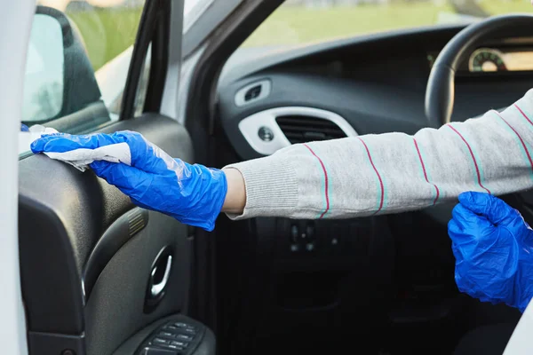 Female hand spraying sanitizer and antiseptic wet wipes for disinfecting car. Cleanliness and healthcare during Corona virus.