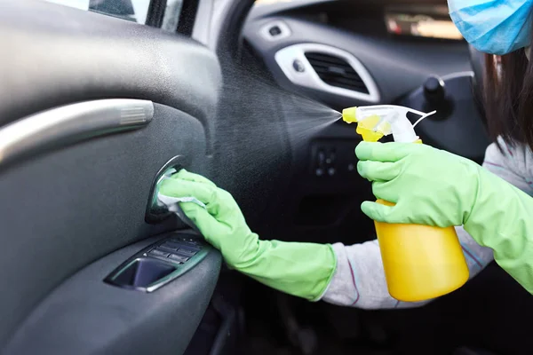 Female hand spraying sanitizer and antiseptic wet wipes for disinfecting car. Cleanliness and healthcare during Corona virus.