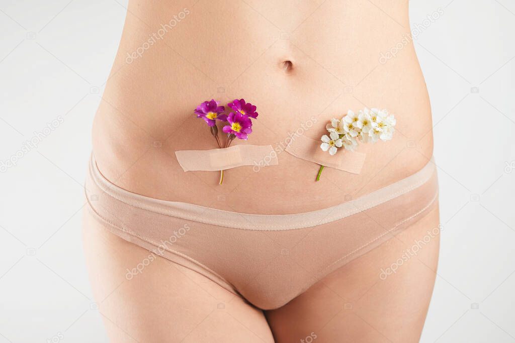 The concept of the health female reproductive system. A beautiful woman with flowers on her skin. preparation for childbirth.