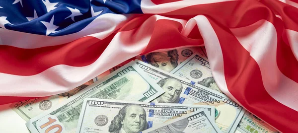 Amerikan bayrağını ve dolar nakitini kapatın. Bir dolar banknot ve arka planda Birleşik Devletler bayrağı. ABD Ekonomisi
