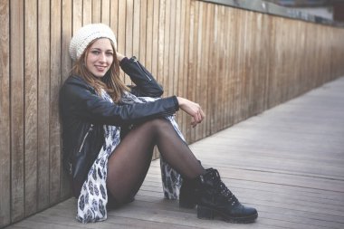 Bir ahşap köprü üzerinde oturan güzel genç kadın