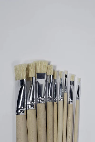 New wooden paint brushes set on light background — Stock Photo, Image