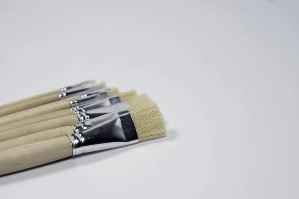 New wooden paint brushes set on light background — Stok fotoğraf