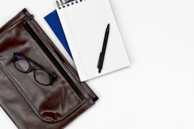 Beyaz ofis masa düzenine. Bardaklar, kahve ve kalemli not defteri. Boşluğu düz olarak kopyala.