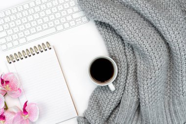 Sıcak kahve, dizüstü bilgisayar ve not defteri olan rahat bir çalışma yeri. Evden çalışıyorum. Yazılıyor. 