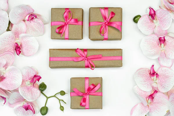 礼品盒横幅，粉色缎带，白色背景平铺兰花。礼物春天的概念. — 图库照片