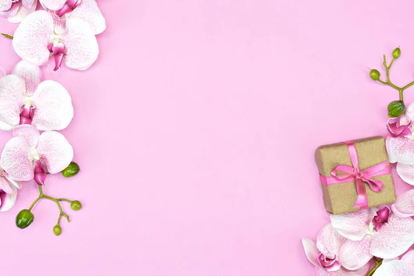 礼物盒的平铺，粉色缎带，粉色背景，兰花。春天的概念。复制空间 — 图库照片
