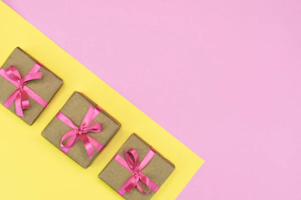 礼物盒的平铺，有粉色和黄色背景的粉色缎带。礼物春天的概念。复制空间 — 图库照片