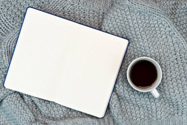 Rahat bir yazma yeri, kazak kahvesi, not defteri. Evden çalışıyorum. Soğuk havada sıcak konsept.