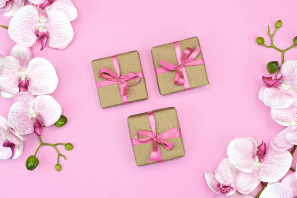 送礼盒的平铺 盒子上有粉红色的缎带 上有粉红色背景的兰花 礼物或礼物春天的概念 复制空间 — 图库照片
