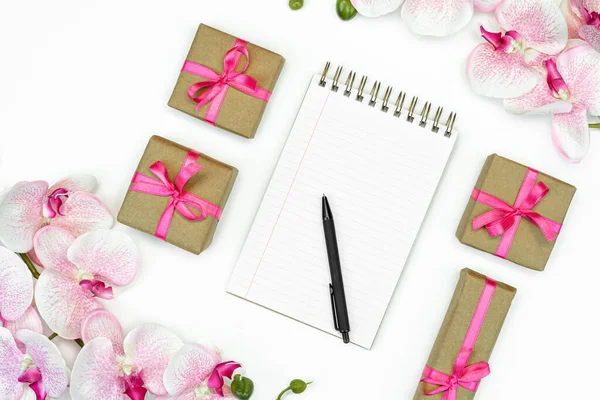送礼盒的平铺 白色背景 顶部有粉色缎带和兰花 笔记本或日记本 礼物或礼物春天的概念 复制空间 — 图库照片