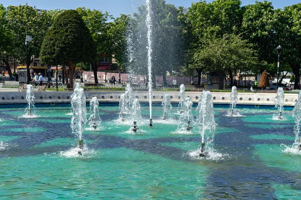 Fontänen i stadsparken med gröna träd på solig dag — Stockfoto