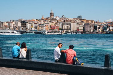 Golden Horn Körfezi, arka planda Galata Köprüsü, gemiler ve Galata Kulesi 'nde insanlar oturuyor. Türkiye, İstanbul, Mayıs 2019