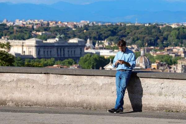 Dospělý Muž Podívá Svůj Telefon Ulici Panoramatem Města Říma Pozadí — Stock fotografie