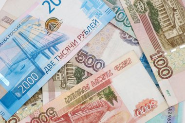 Rus parasının 100, 500, 1000, 2000, 5000 rublelik banknotları kaotik bir şekilde düzenlenmiştir..