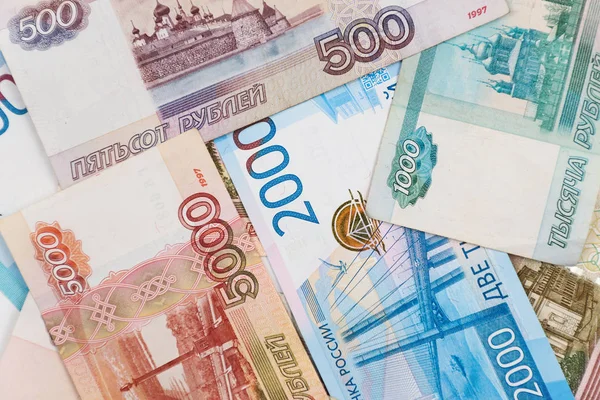 Rus parasının 100, 500, 1000, 2000, 5000 rublelik banknotları kaotik bir şekilde düzenlenmiştir..