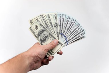Beyaz bir arka plan üzerinde elinde yüz dolar faturaları.