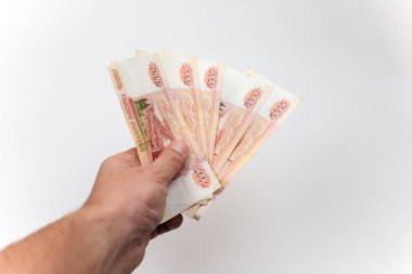 Rus parası, beyaz arka planda 5000 dolar tutuyor..