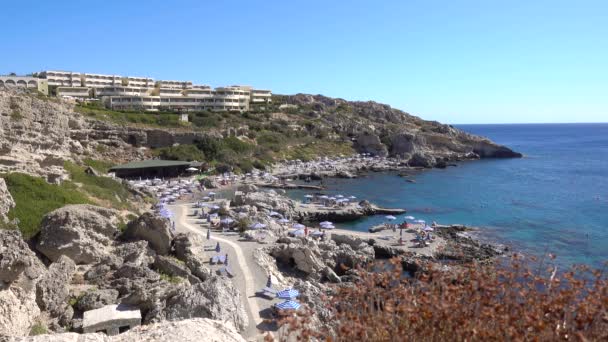 地中海 岩石海岸 一个阳光灿烂的日子 海湾是一个有游客的旅馆 罗得岛希腊 — 图库视频影像