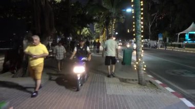 Pattaya, Pattaya 'da akşam yürüyüşü. İnsanlar, arabalar, ışıklar, palmiye ağaçları, turistler, deniz, sahil. Pattaya, Tayland 7.12.2017